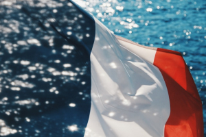 Französische Flagge vor glitzerndem Meer